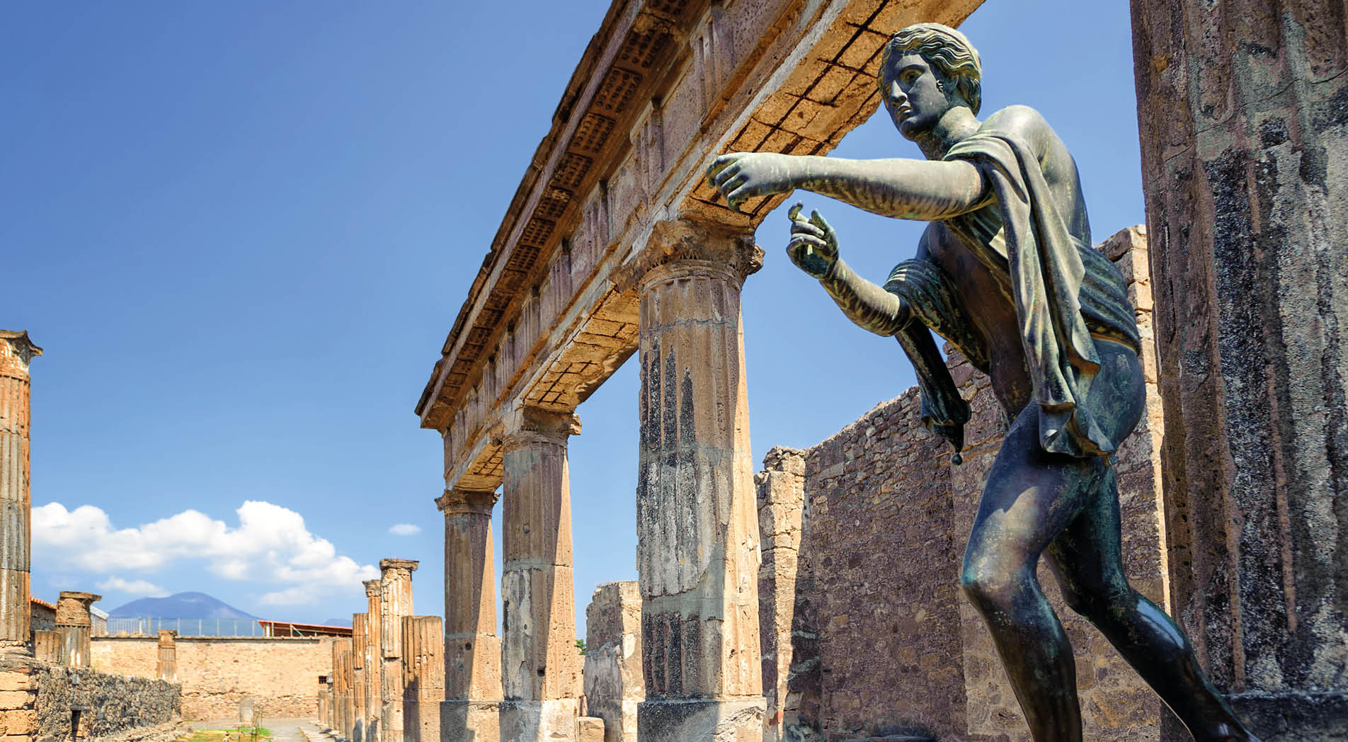 Ruins of the antique Temple of Apollo with bronze Apollo statue in Pompeii, Naples, Italy. Pompeii was destroyed by Vesuvius eruption in 79 AD.