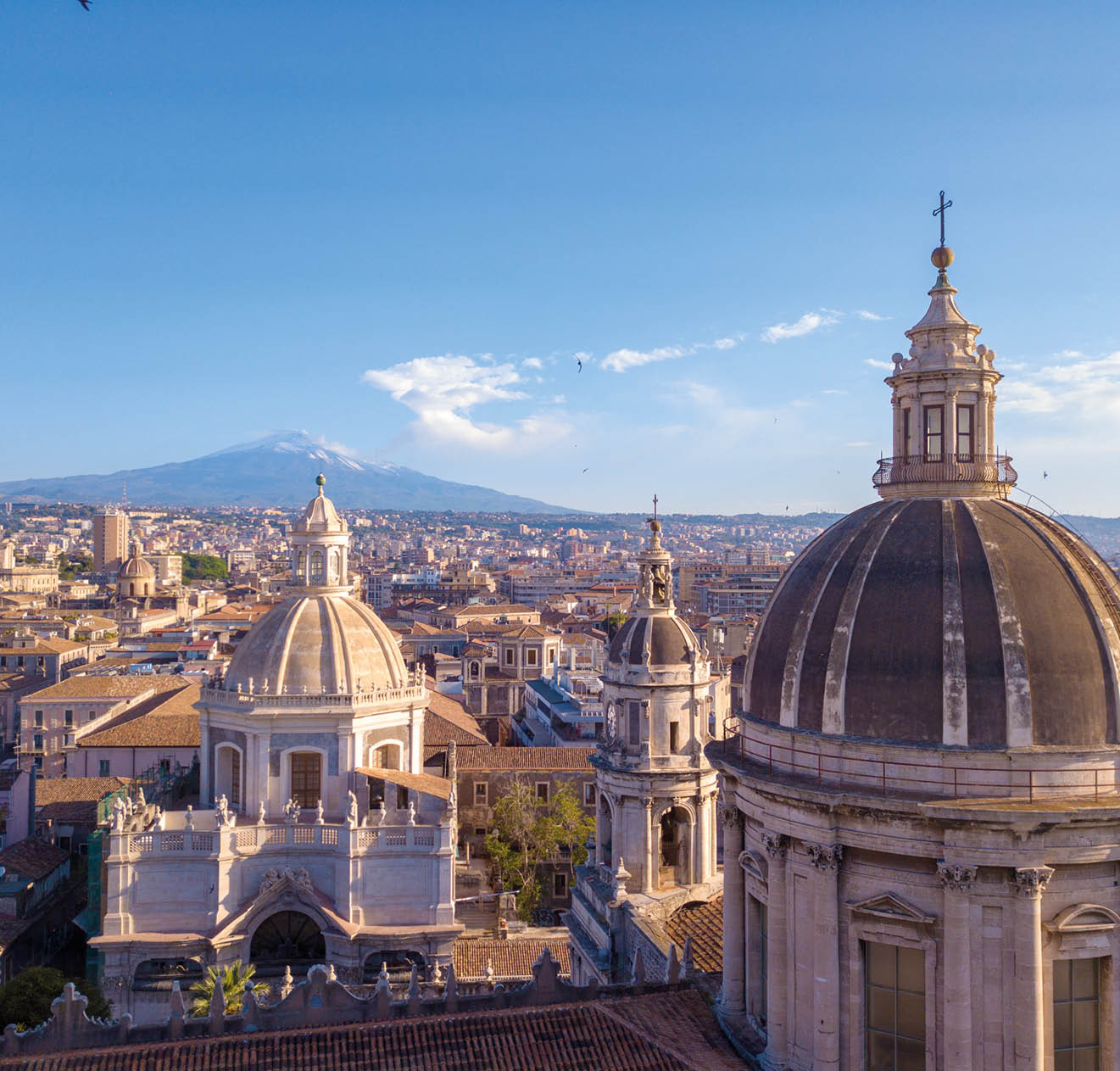 Beautiful aerial view of the Catania city near the main Cathedral and Etna volcano on the background. Amazing old town view from above.