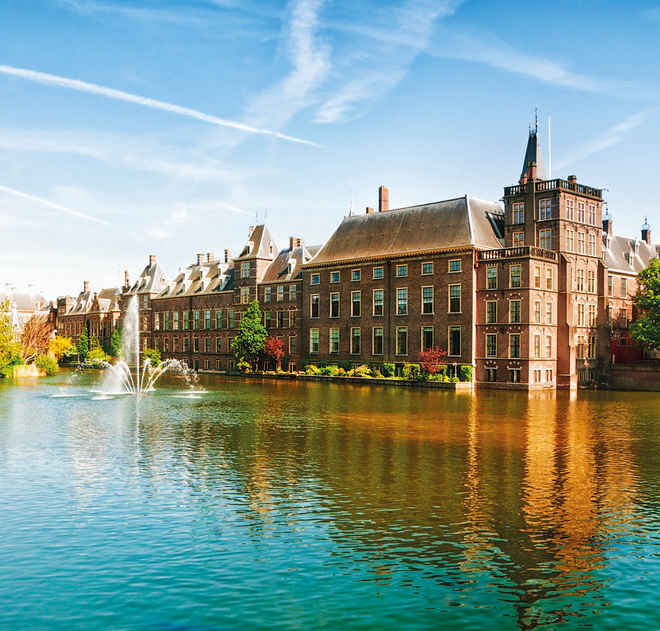 Binnenhof (Dutch Parliament), The Hague (Den Haag), The Netherlands. Visible are Historic buildings, art museum Mauritshuis along the pond Hofvijver, fountain and beautiful cloudscape over the reflection in the water.