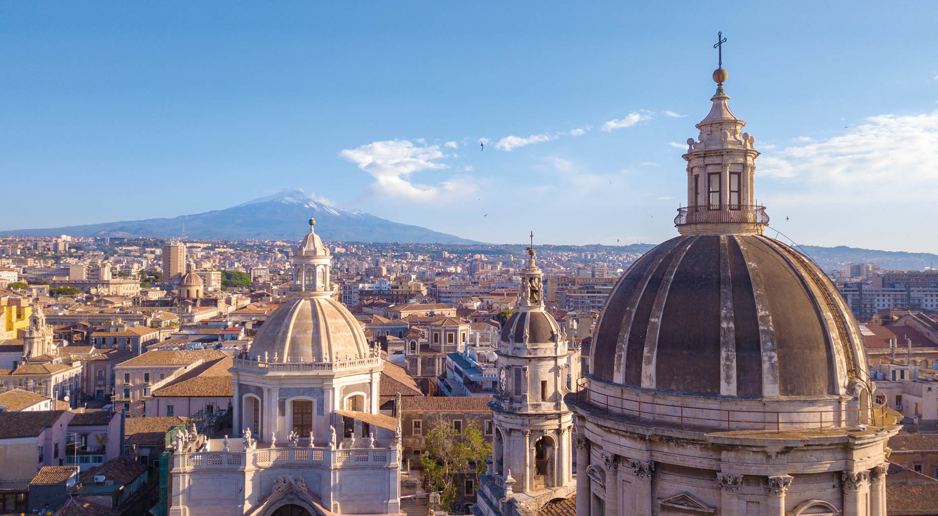 Beautiful aerial view of the Catania city near the main Cathedral and Etna volcano on the background. Amazing old town view from above.