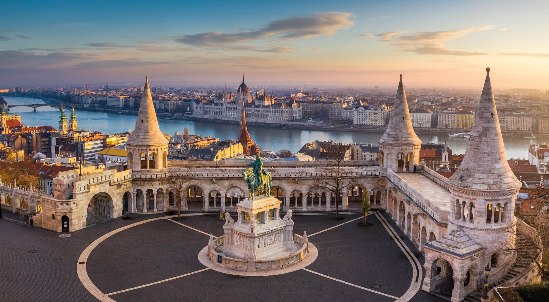 Budapest, Hungary - The famous Fisherman's Bastion at sunrise with statue of King Stephen I and Parliament of Hungary at background