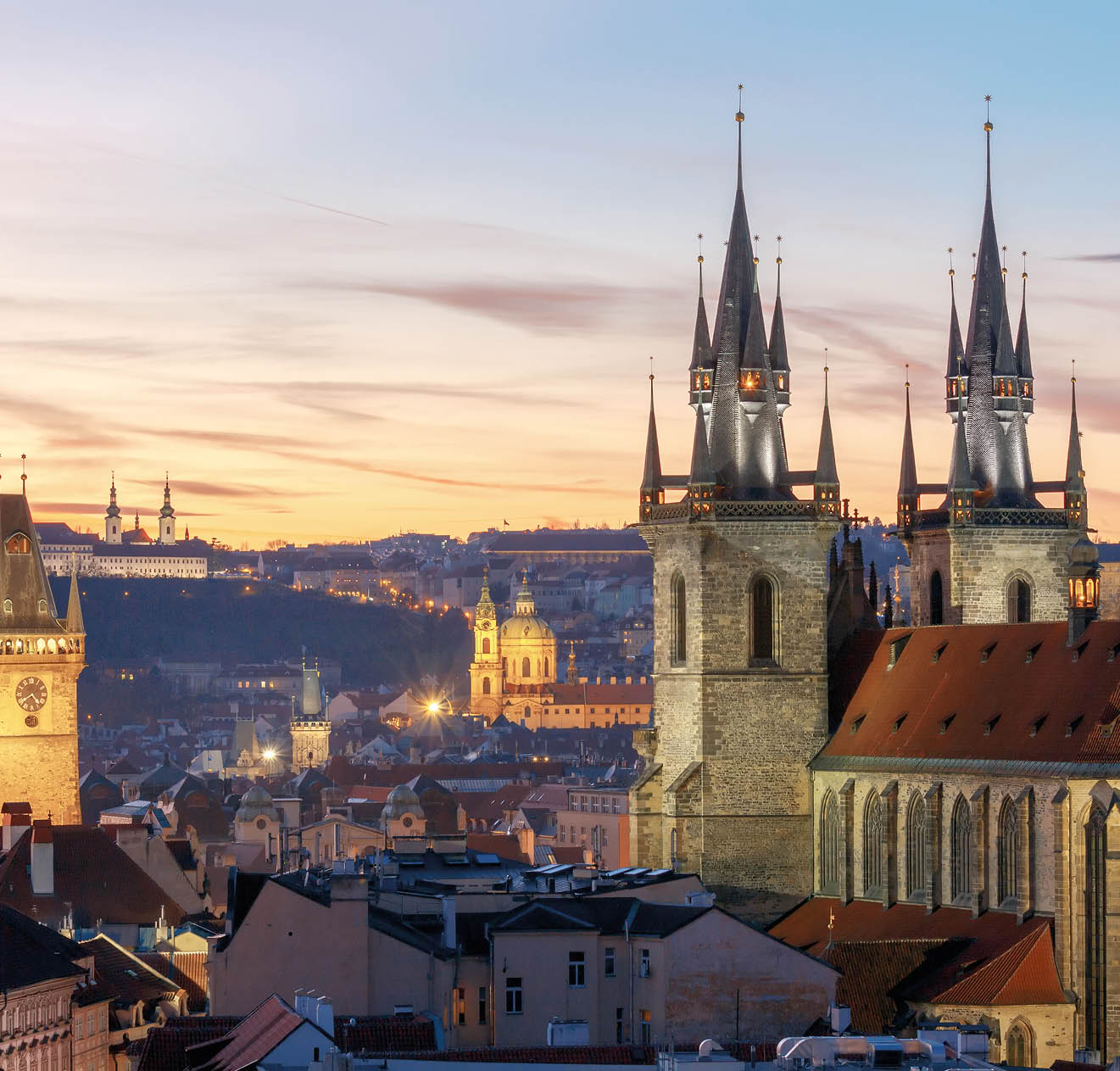 View of the Church of Our Lady before Tyn and St. Vitus Cathedral at sunset.