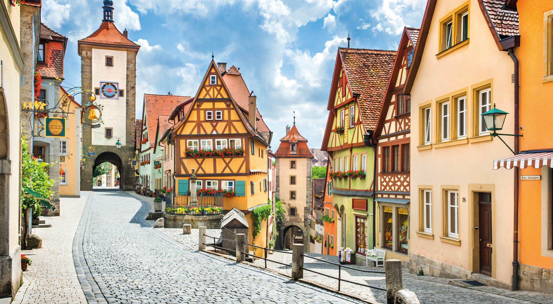 Beautiful postcard view of the famous historic town of Rothenburg ob der Tauber on a sunny day with blue sky and clouds in summer, Franconia, Bavaria, Germany