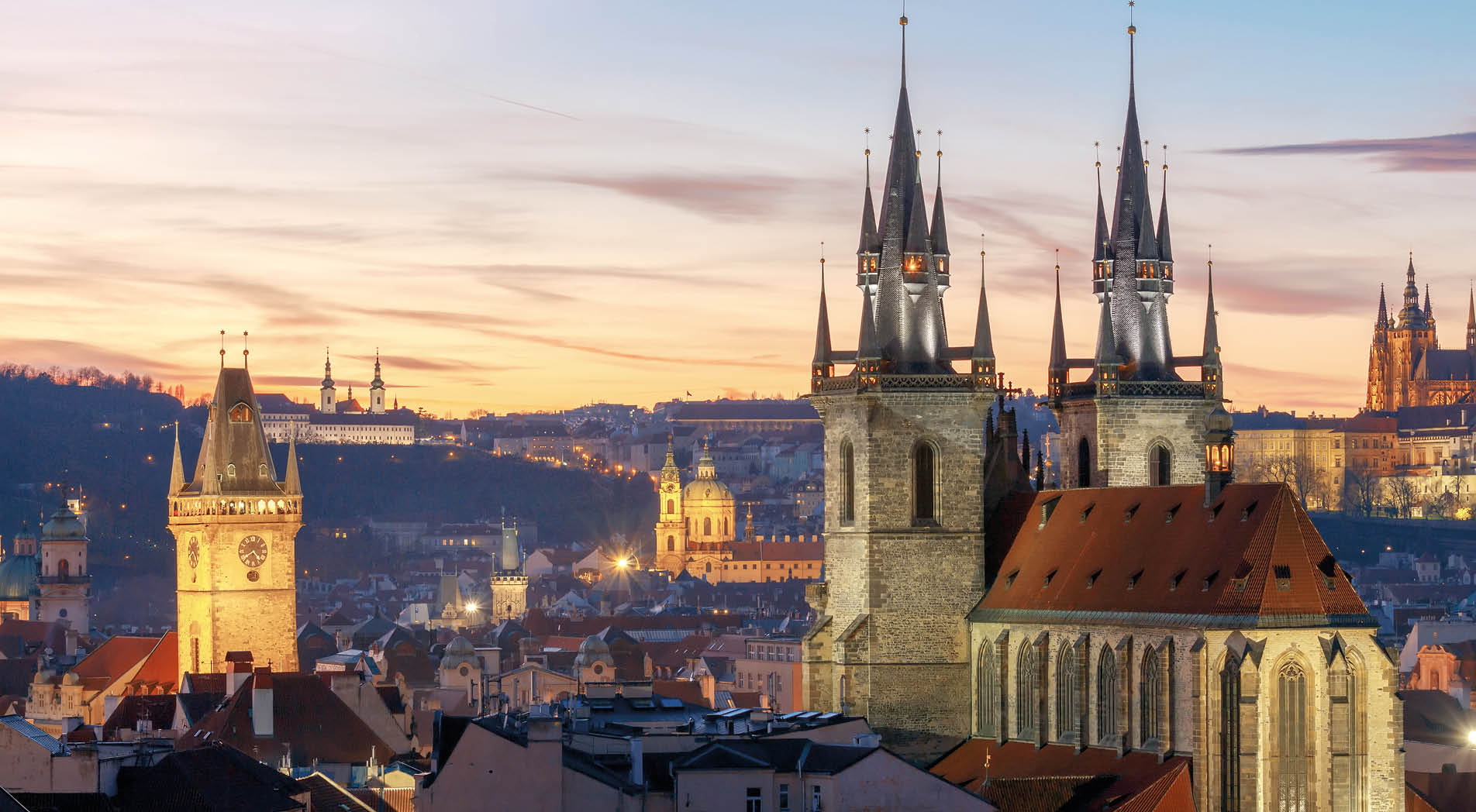 View of the Church of Our Lady before Tyn and St. Vitus Cathedral at sunset.
