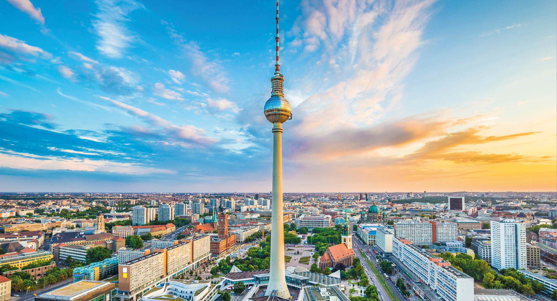 Berlin skyline panorama with famous TV tower at Alexanderplatz and dramatic cloudscape at sunset, Germany.