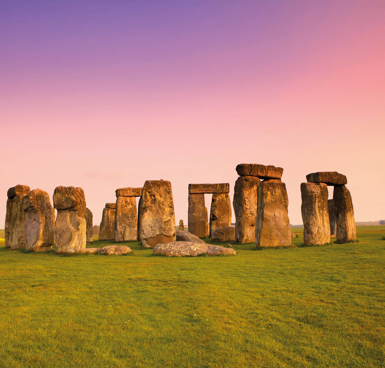 Ancient stones at UNESCO World Heritage Site at Stonehenge, Wiltshire, UK. Dramatic sky and golden hues of dusk. Major tourist destination, archeological and pilgrimage site during Summer Solstice and Winter Solstice.