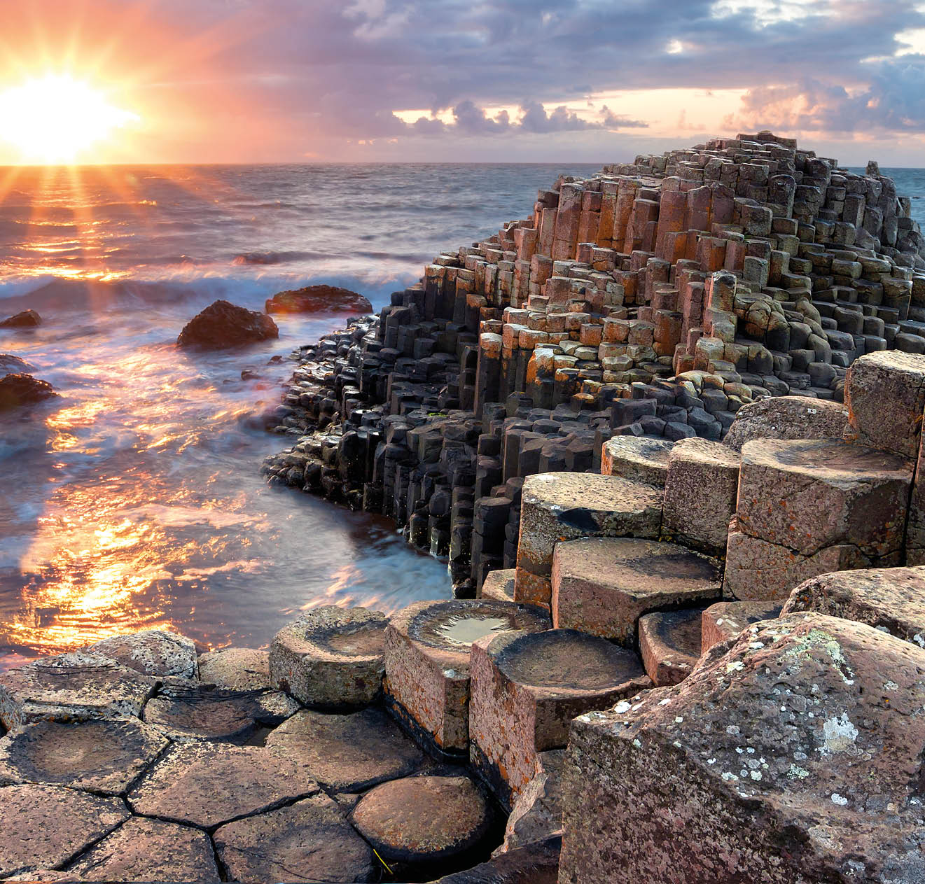 People visiting Giant s Causeway at the sunset in North Antrim, Northern Ireland