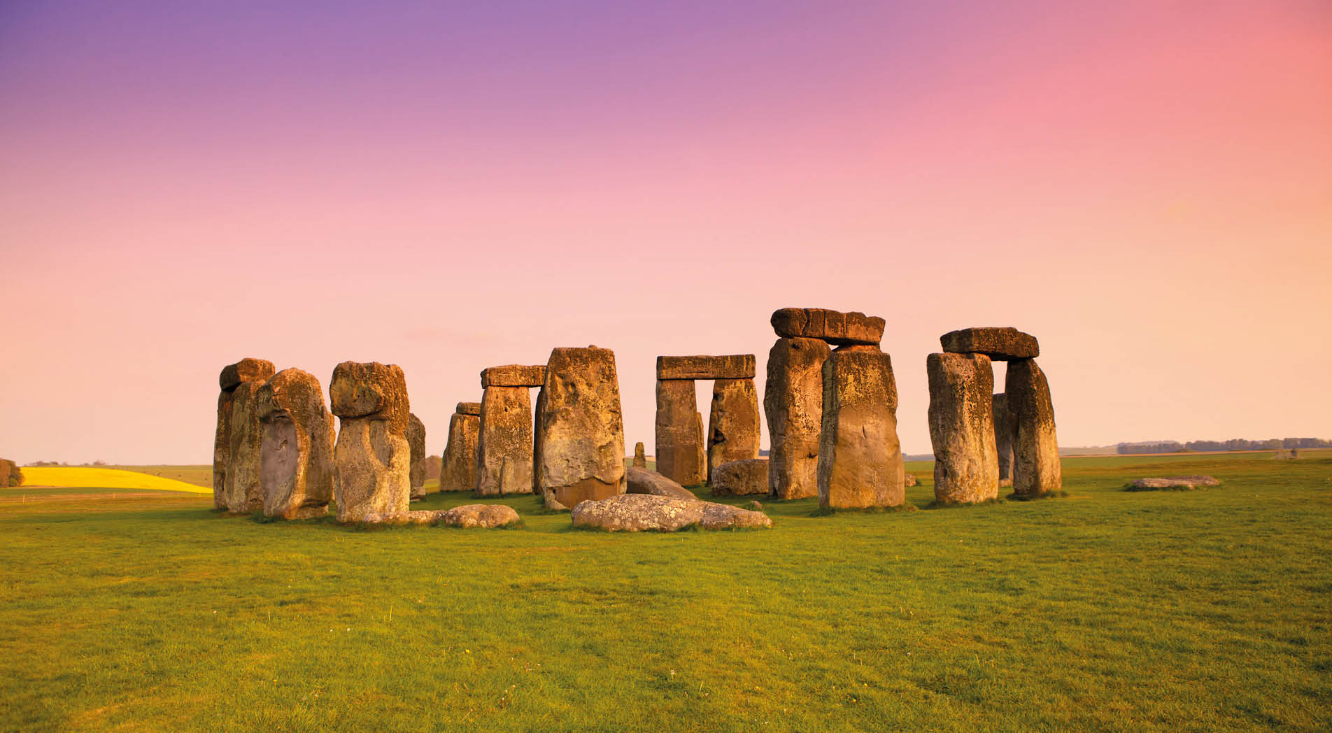 Ancient stones at UNESCO World Heritage Site at Stonehenge, Wiltshire, UK. Dramatic sky and golden hues of dusk. Major tourist destination, archeological and pilgrimage site during Summer Solstice and Winter Solstice.