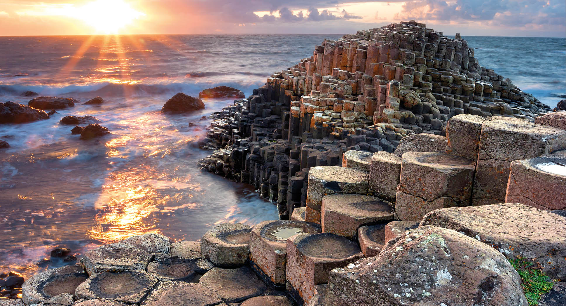 People visiting Giant s Causeway at the sunset in North Antrim, Northern Ireland