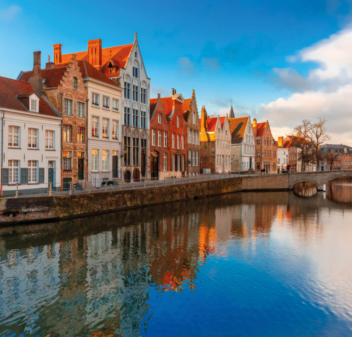 Scenic city view of Bruges canal Spiegelrei with beautiful medieval houses, their reflections and Bridge Carmersbrug, Belgium