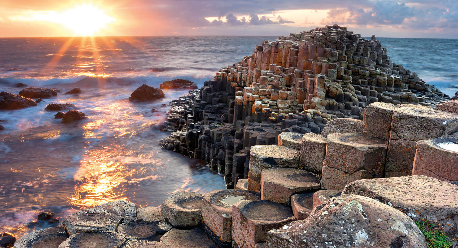 People visiting Giant s Causeway at the sunset in North Antrim, Northern Ireland
