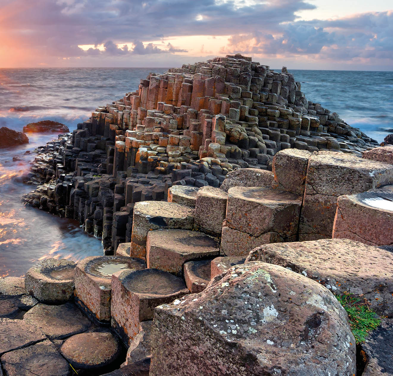 People visiting Giant s Causeway at the sunset in North Antrim, Northern Ireland